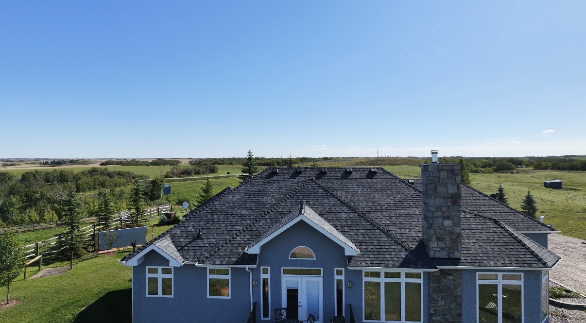 Aerial view of a Saskatoon home with a new dark asphalt shingle roof installed by No Stress Roofing