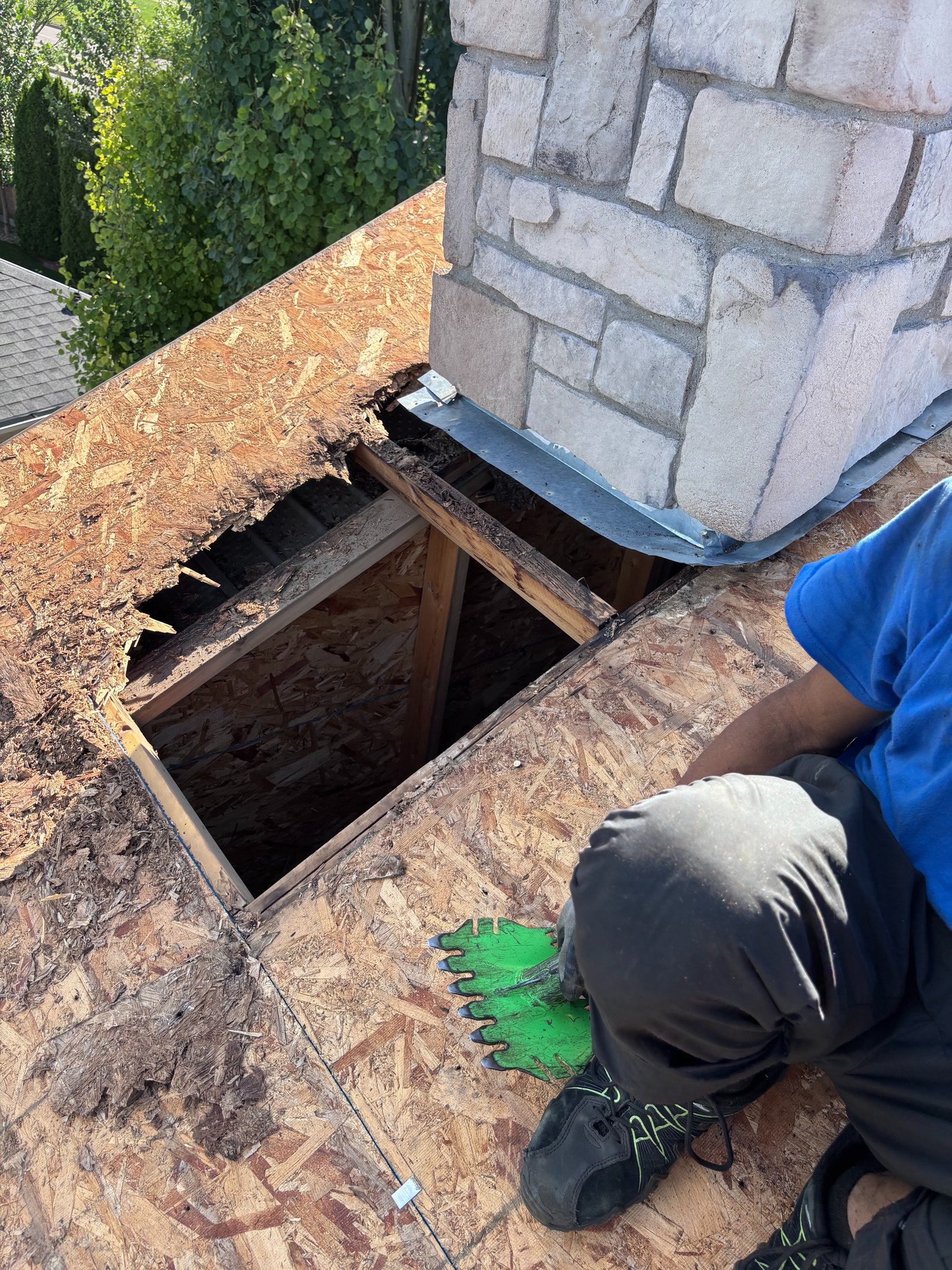 No Stress Roofing crew member doing a full roof tear-off around a stone chimney