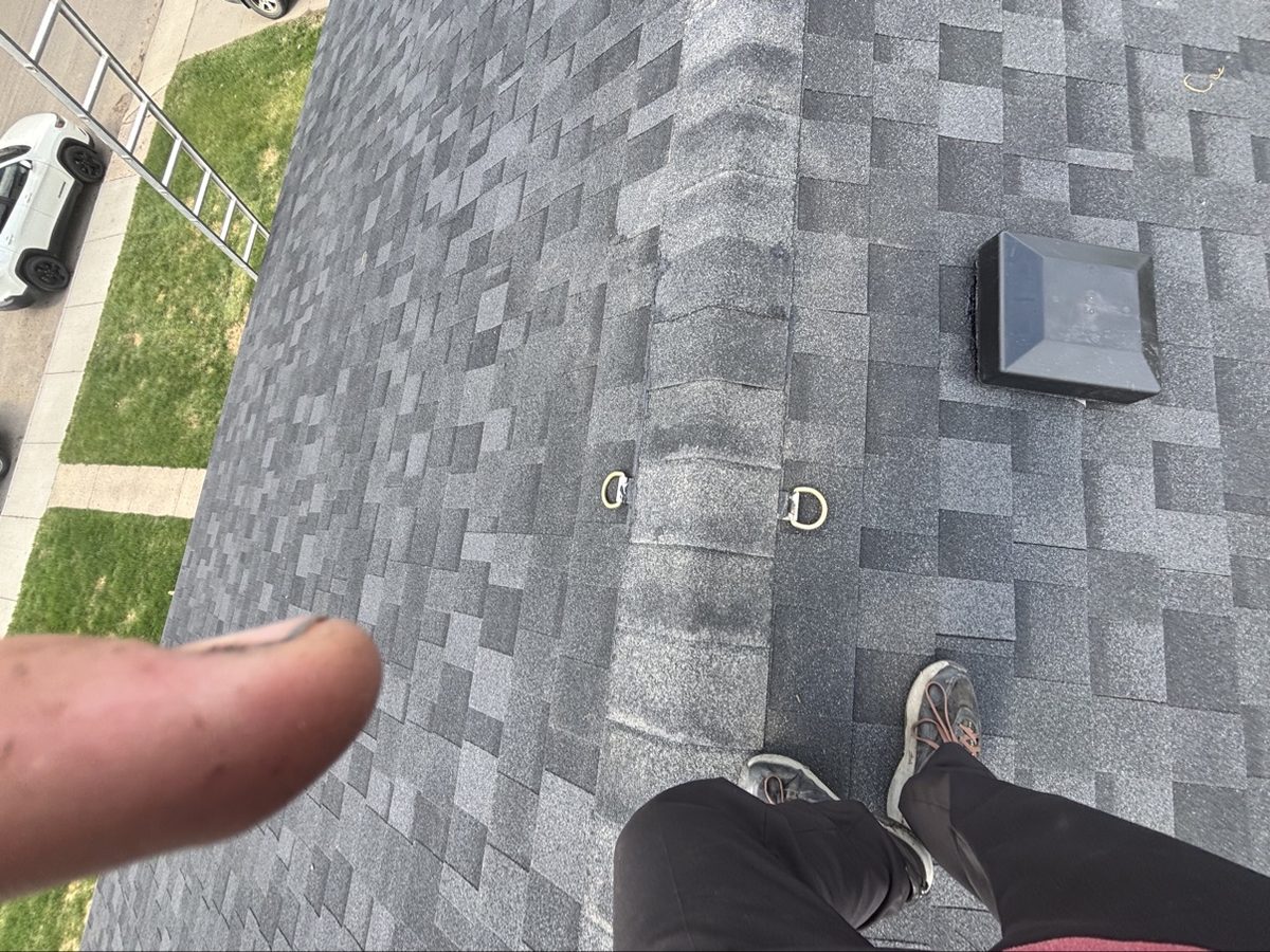 Roofer standing on a newly installed shingle roof